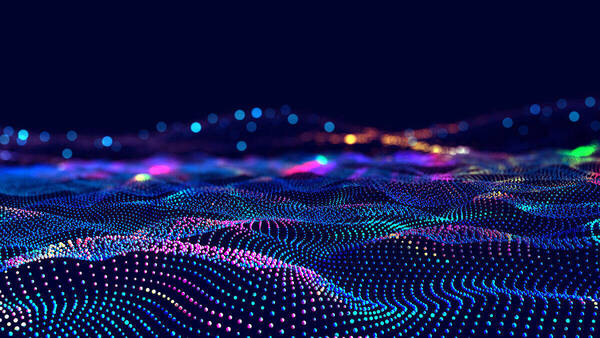 Abstract digital landscape of shimmering, multi-colored data points forming undulating waves on a dark blue background.