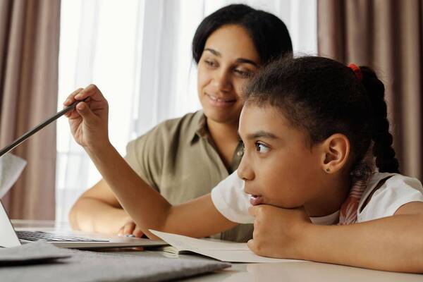 A mother works with her daughter on a lesson at home. A new study co-authored by a Notre Dame researcher explores how AI can support priorities of homeschooling parents, including adaptable routines, value-aligned materials and community-based support.