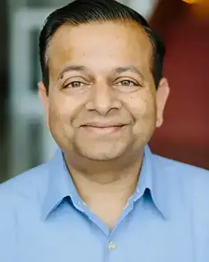 Man in blue shirt smiling at the camera.